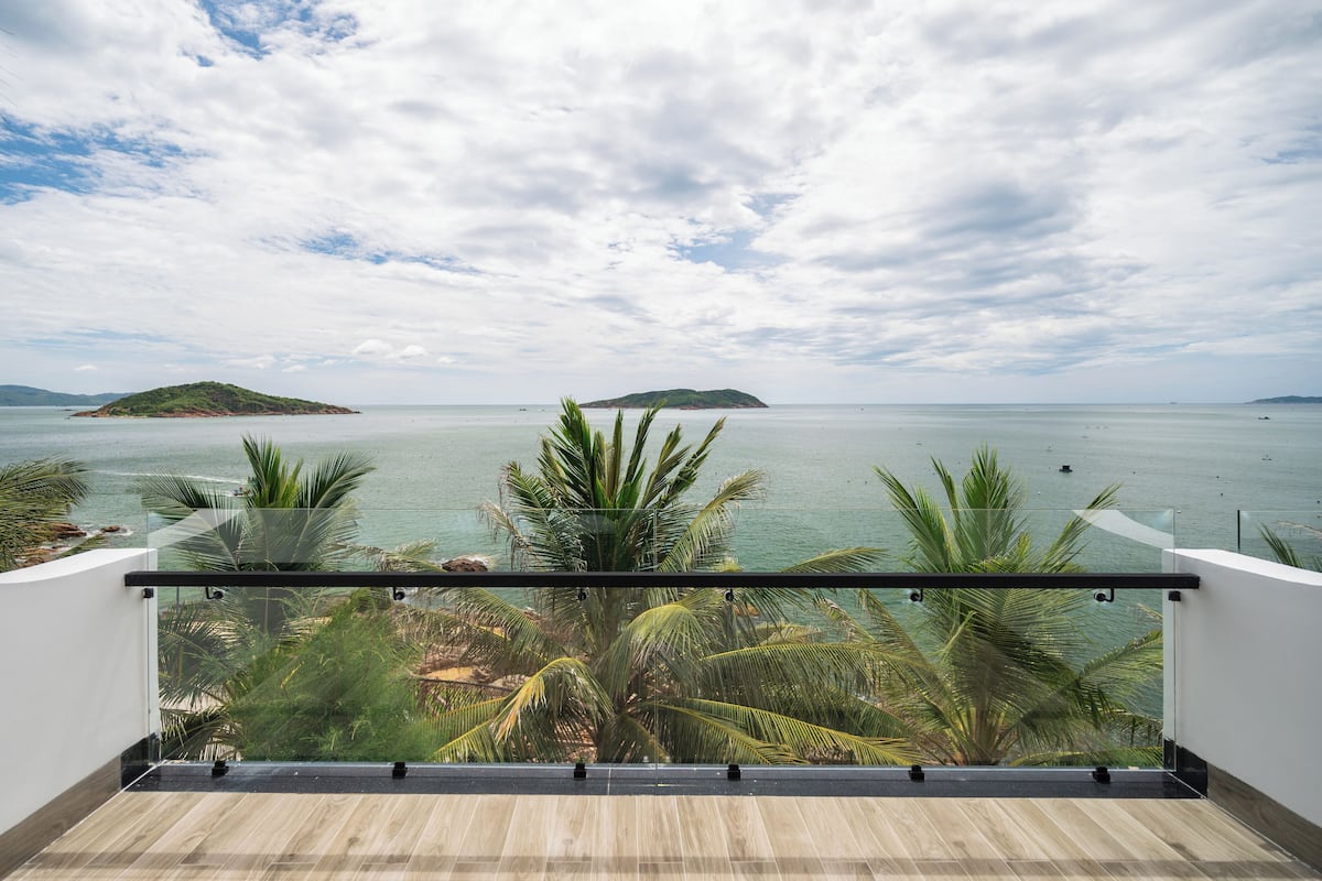 A balcony with a view of the sea and a distant island.