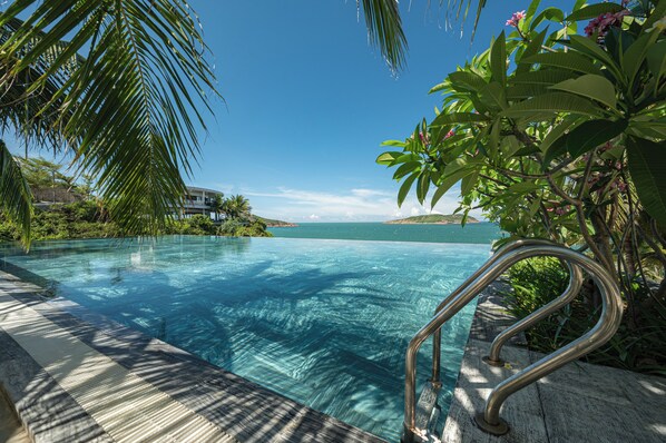 A clear blue infinity pool with a view of the sea and a distant island. - Quy Nhon Sea Resort (Quy Nhon Nam)