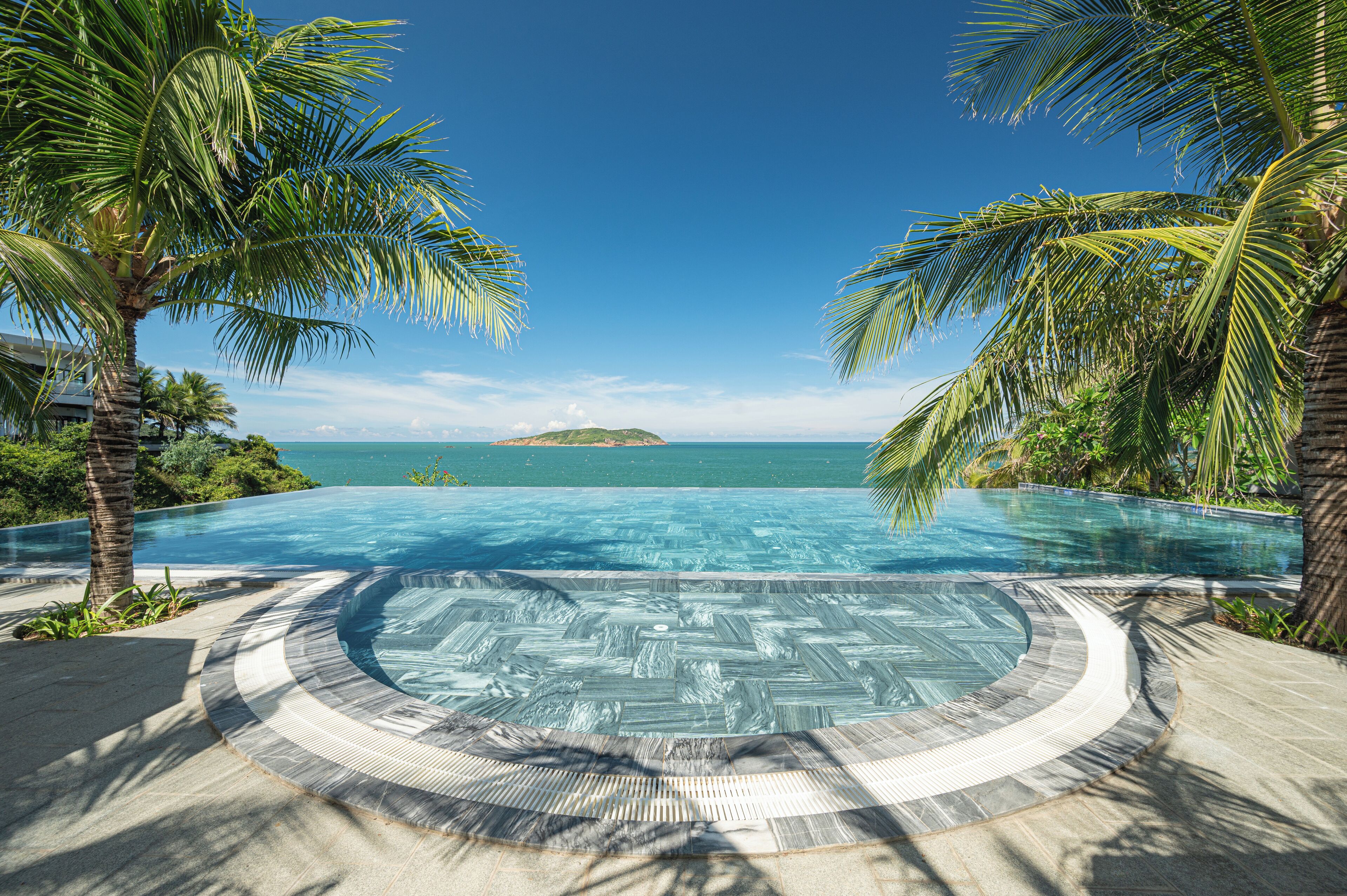 Una piscina al aire libre, sombrillas, sillones reclinables de piscina