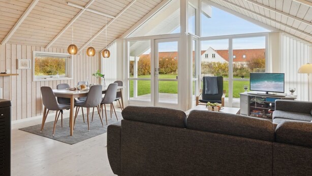 A spacious living area with a large window, a dining table, and a sofa. - "Terne" - 90m from the sea by Interhome (Nykøbing Sj)