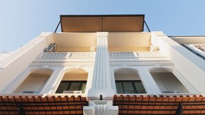 Un edificio con una columna central, ventanas arqueadas y una terraza cubierta.