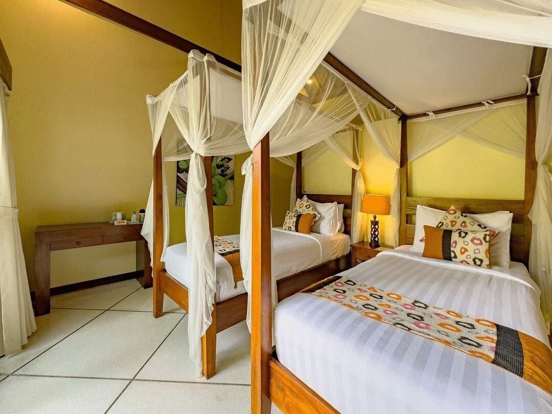 A four-poster bed with a canopy, two bedside tables, and a nightstand with a lamp.