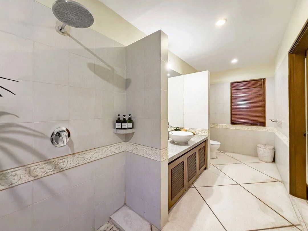 A modern bathroom with a shower, toilet, and sink.