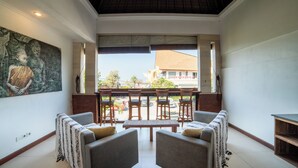 A room with a balcony, seating area, and a mural on the wall. - Island Getaway Villa (Denpasar)