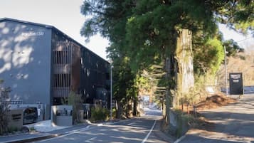 A building with a sign reading 'Roxulian STAY' and a parking lot with a few cars.