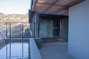 A modern outdoor area with a pool, glass doors, and a view of a hillside. - Rakuten STAY FUJIMI TERRACE Hakone Ashinoko (Hakone)