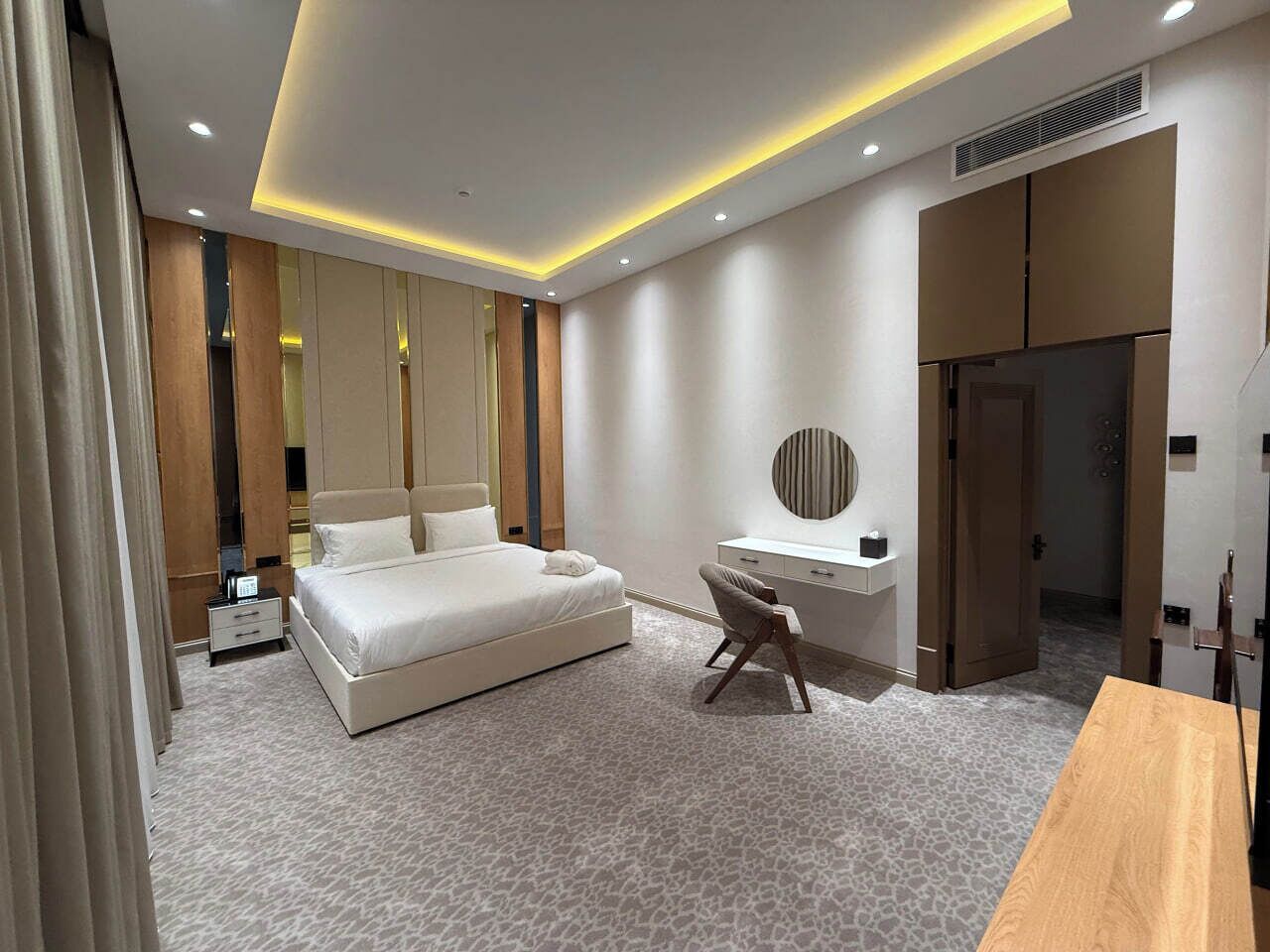 Una habitación de hotel moderna con una cama grande, un escritorio y un armario.