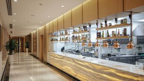A modern kitchen with marble countertops and wooden cabinets. - AD Bellagio Hotel (Samarkand)
