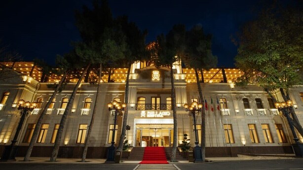 A grand hotel with a red carpet entrance, large windows, and a prominent sign. - AD Bellagio Hotel (Samarkand)