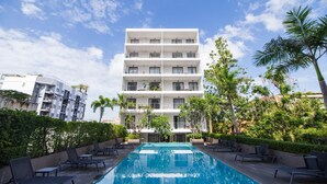 A modern multi-story building with a swimming pool and lounge chairs. - Cozy & Modern -1BR T2 416 (Chalong)