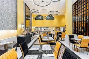 A restaurant with high ceilings, pendant lighting, and a long counter with seating. - Kastel Bangkok Hotel (Bangkok)