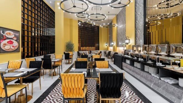 Een restaurant met meerdere eettafels, stoelen en een bar.