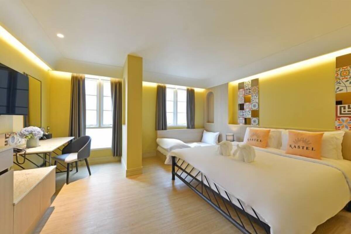 A hotel room with a bed, a desk, and a chair.