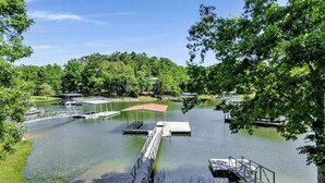 Un port de plaisance doté de plusieurs quais et abritant de nombreux bateaux, entouré d’une végétation luxuriante et d’arbres.