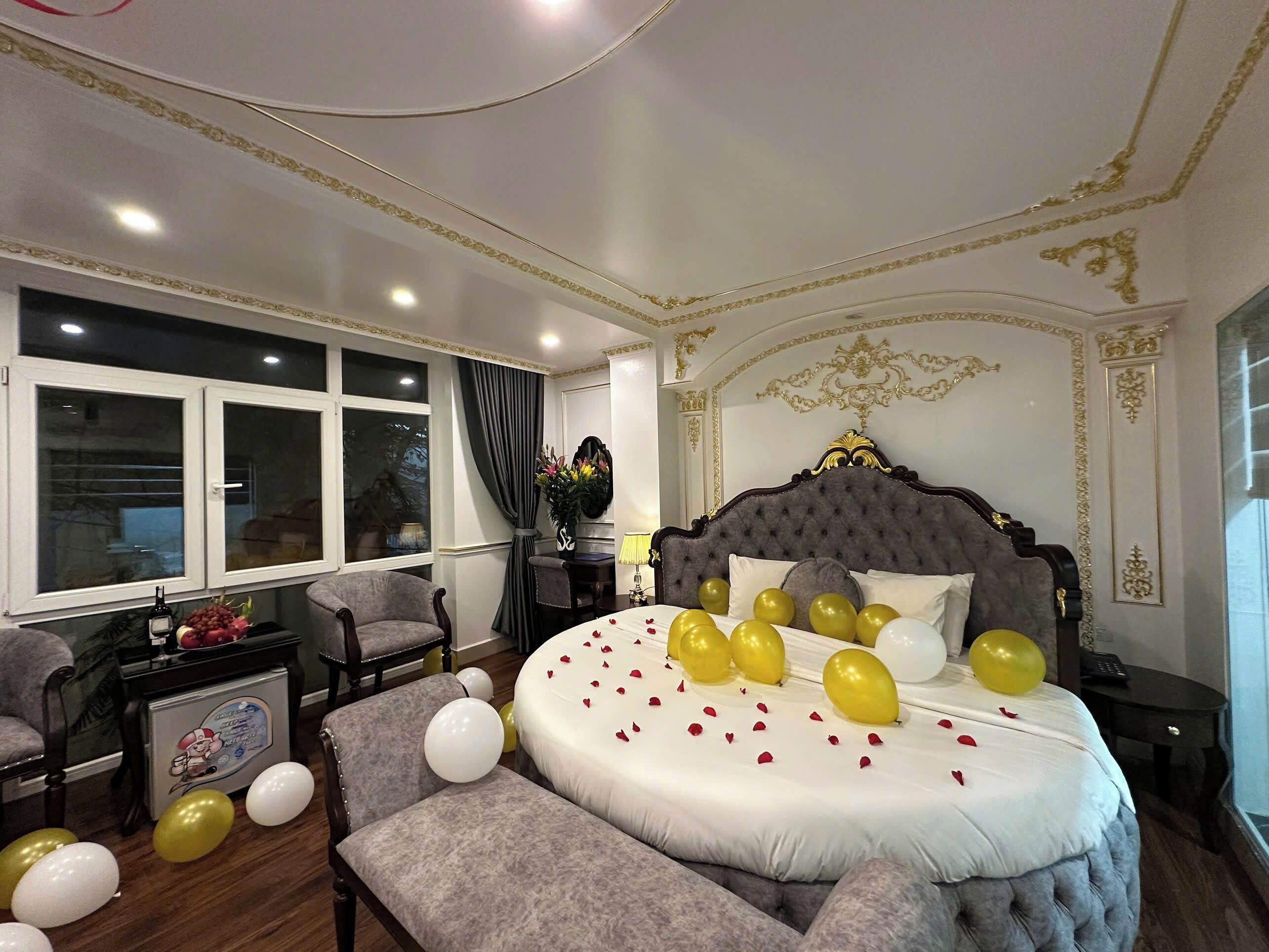 A bedroom with a large bed, a window, and a chair.