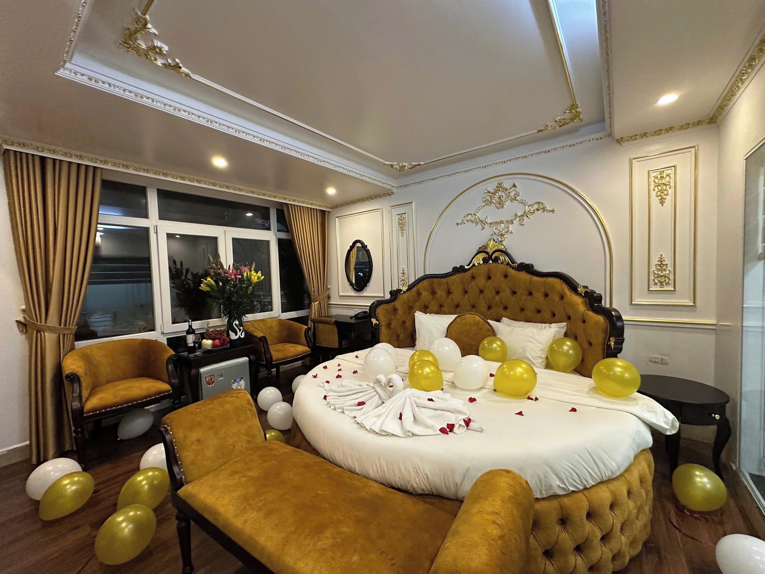 A luxurious bedroom with a large bed, a sitting area, and a dining table.