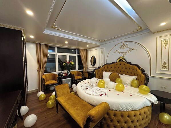 A luxurious bedroom with a large bed, a bench, and a small table. - Aloha Hotel (Hanoi)