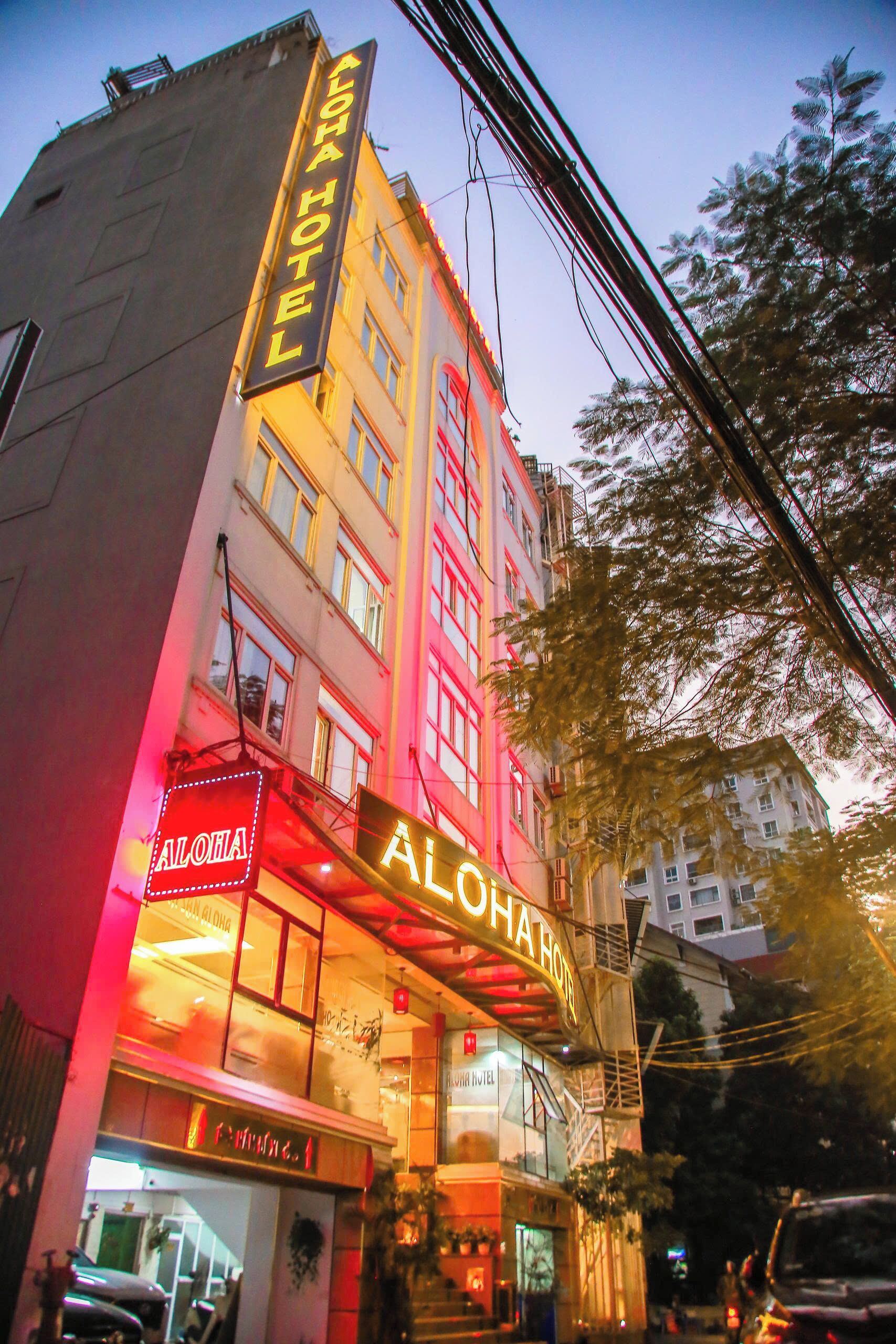 A hotel with a prominent sign reading "ALOHA HOTEL" and a visible entrance.