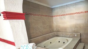Une salle de bain avec une baignoire, un porte-serviettes et une zone de douche carrelée.
