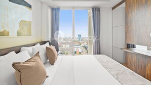 Habitació d'hotel amb un llit gran, vista a la ciutat i un disseny modern.