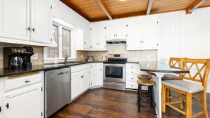 A kitchen with white cabinets, stainless steel appliances, and a wooden ceiling. - 💥New💥Sandy Beach! Main lake, kayaks, dock, hot tub, theater, game room, dogs! (Henrico)