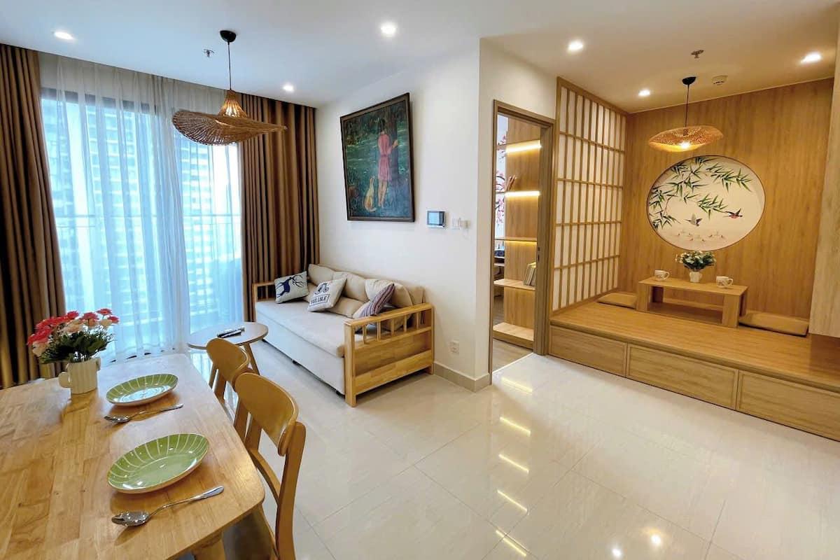 A modern living room with a sofa, dining table, and a traditional Japanese sliding door.