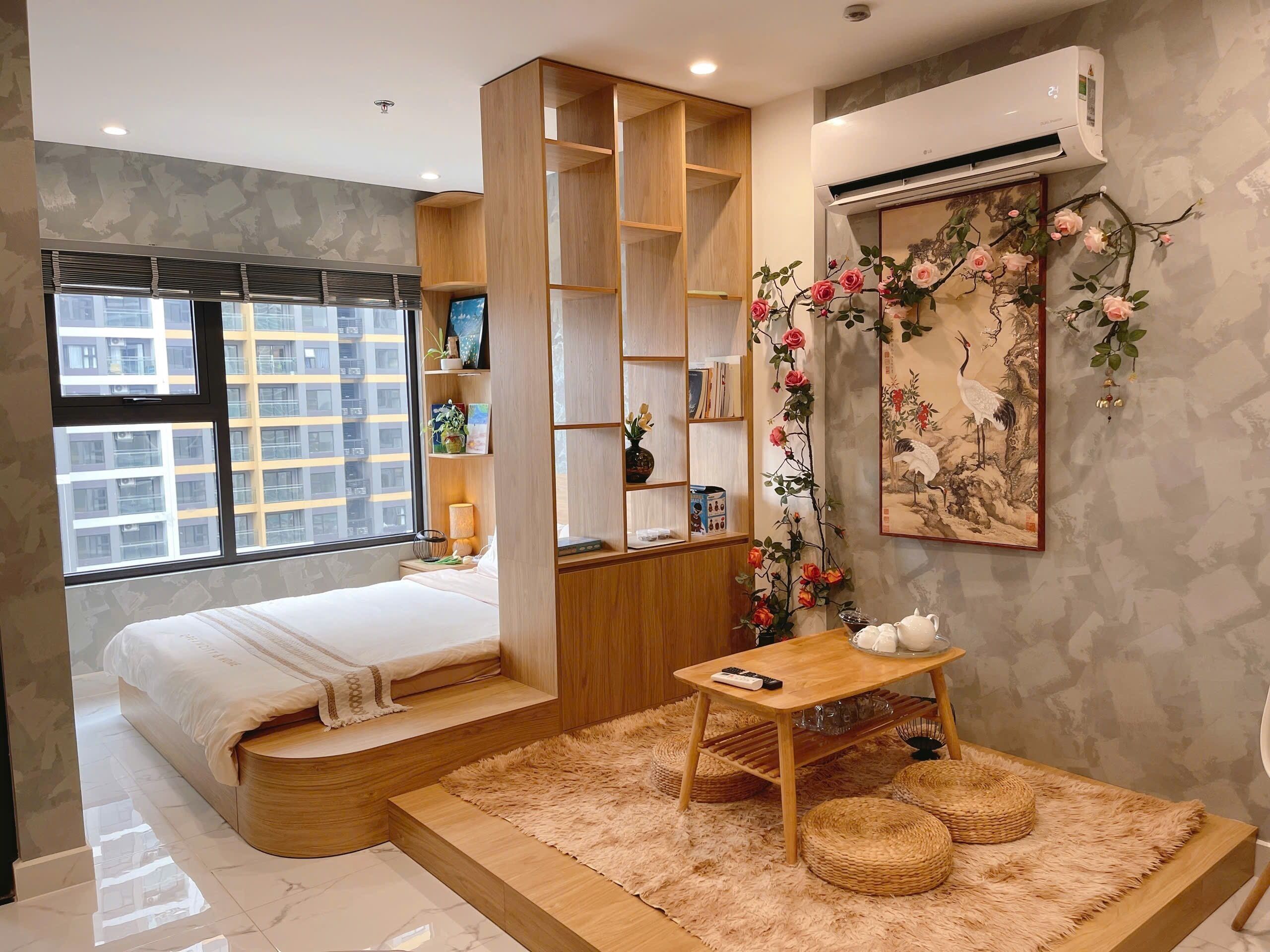 Un dormitorio moderno con cama, estanterías de madera empotradas, una mesita pequeña y un adorno en la pared.