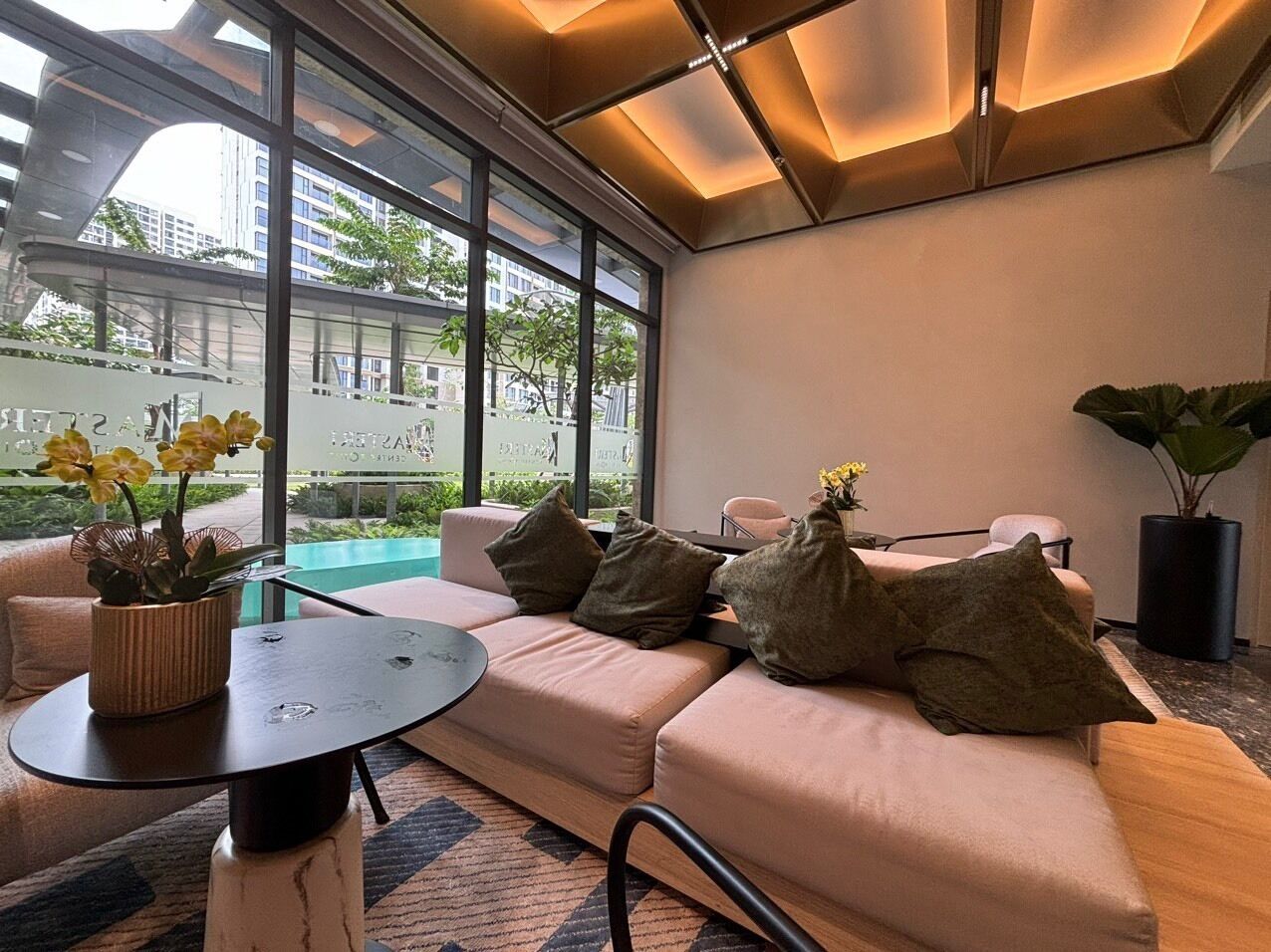 A modern living room with a sofa, a round table, and a potted plant.
