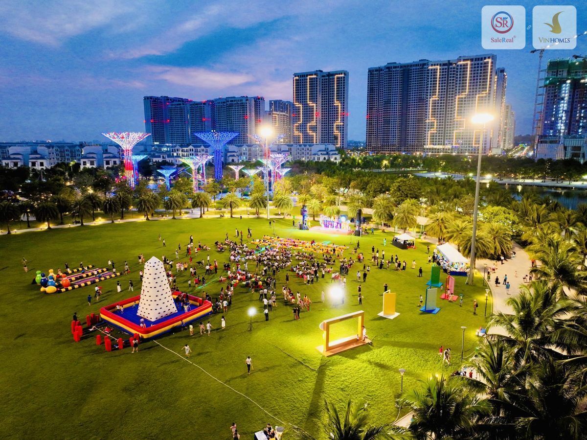 A park with a large open field, a pyramid-shaped fountain, and a stage for events.