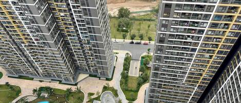 Un edificio residencial alto con varios balcones, piscina y áreas ajardinadas.