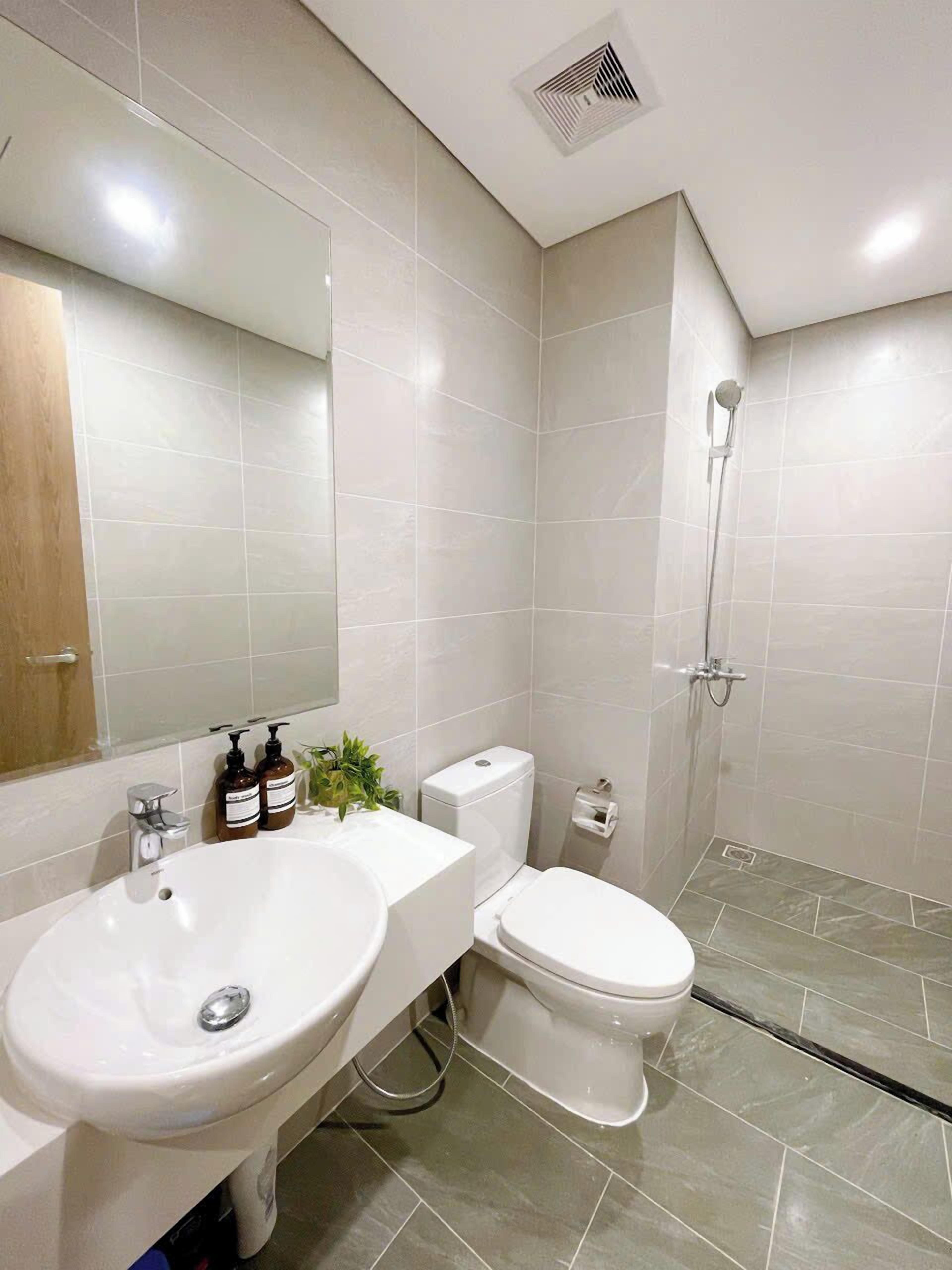 Ein modernes Badezimmer mit Waschbecken, Toilette und Dusche, alles in Weiß.