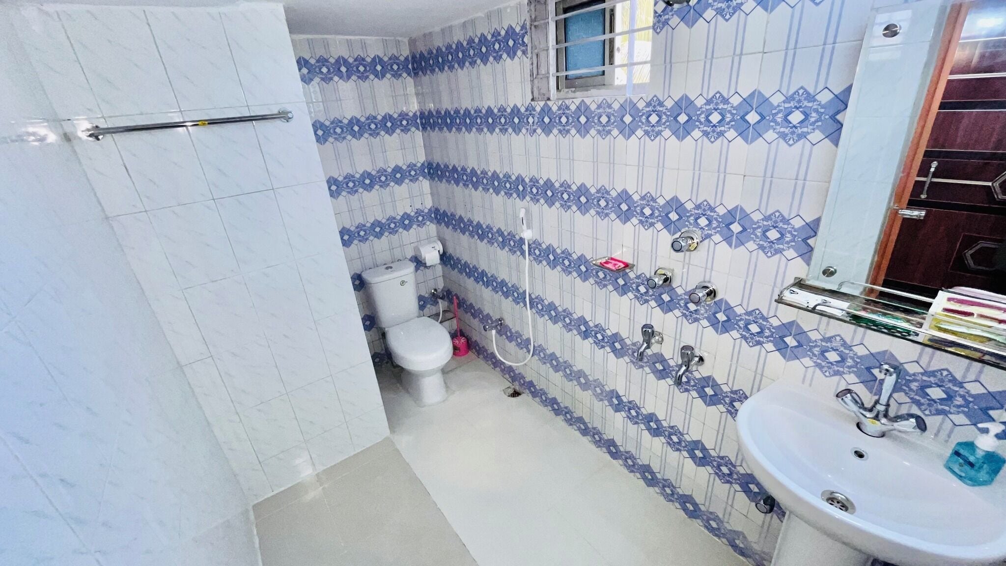 Un baño con inodoro, lavamanos y zona de ducha.