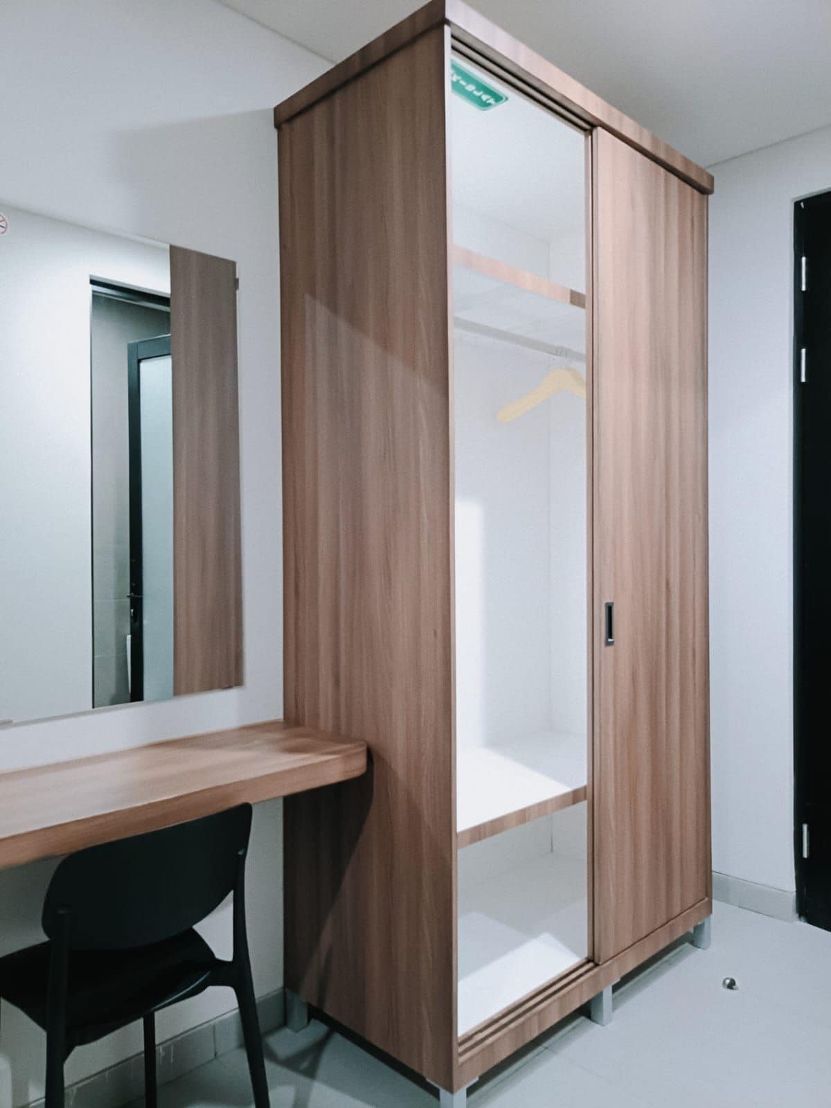 Una habitación con un armario de madera, un escritorio y una silla.