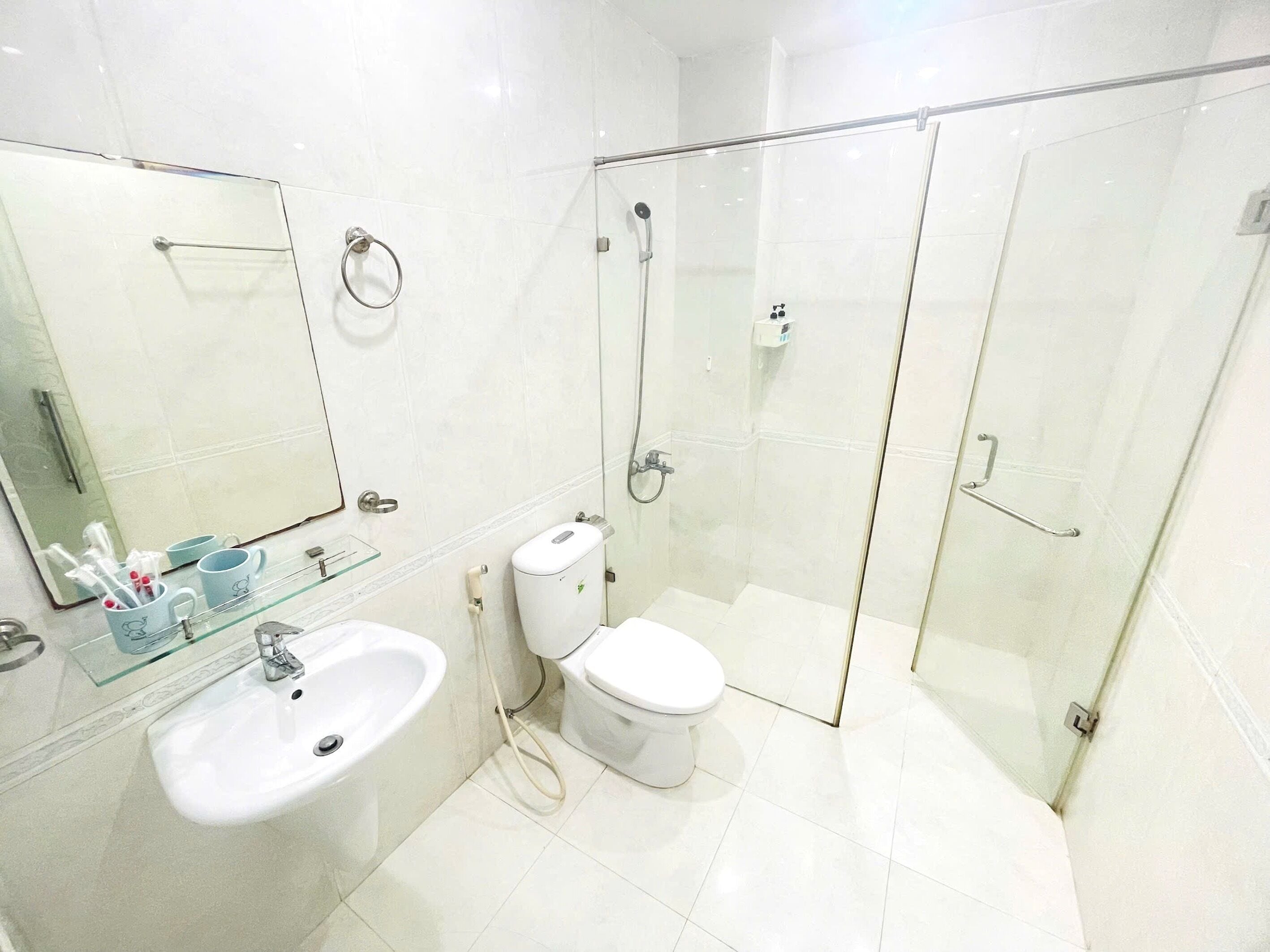 A modern bathroom with a glass-enclosed shower, a sink, and a toilet.