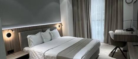 Caixa forta a l'habitació, cortines opaques i planxa i posts de planxar