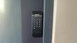 A door with a digital keypad and a keyhole lock.