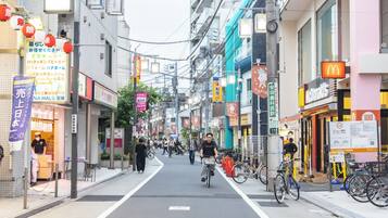 Una calle con bicicletas, peatones y diversas tiendas, incluyendo un McDonald's.