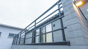 A building with a modern design, featuring a balcony with metal railings, large windows, and a textured facade. - Ars Garden Omori (Tokyo)