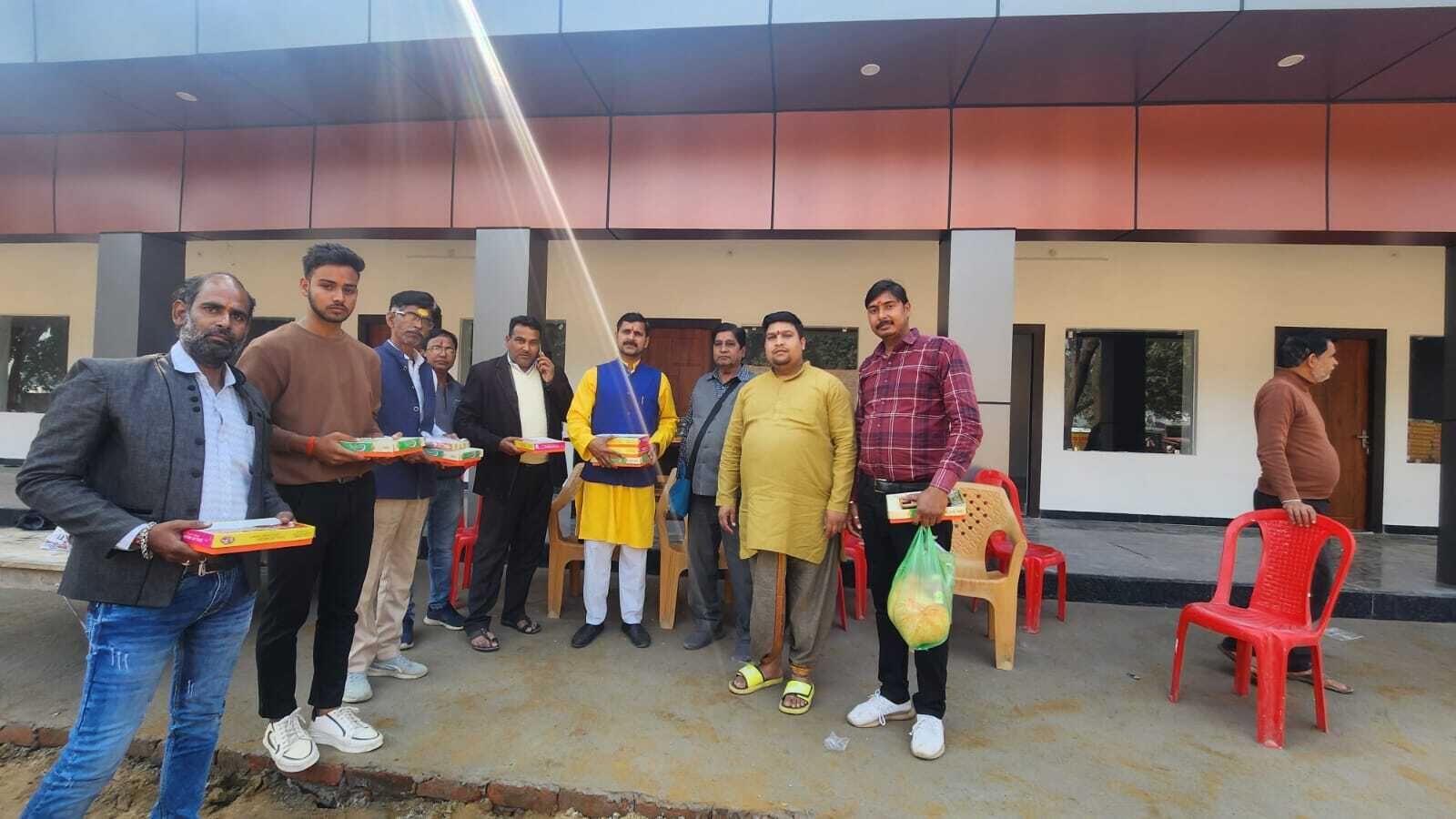 A group of people standing in front of a building with a modern design, holding items.