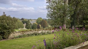 A stone wall with a garden in the foreground, a stone wall with a garden in the foreground, and a stone wall with a garden in the foreground. - Elegant dog friendly home with panoramic views - The Old Vicarage (Aldsworth)