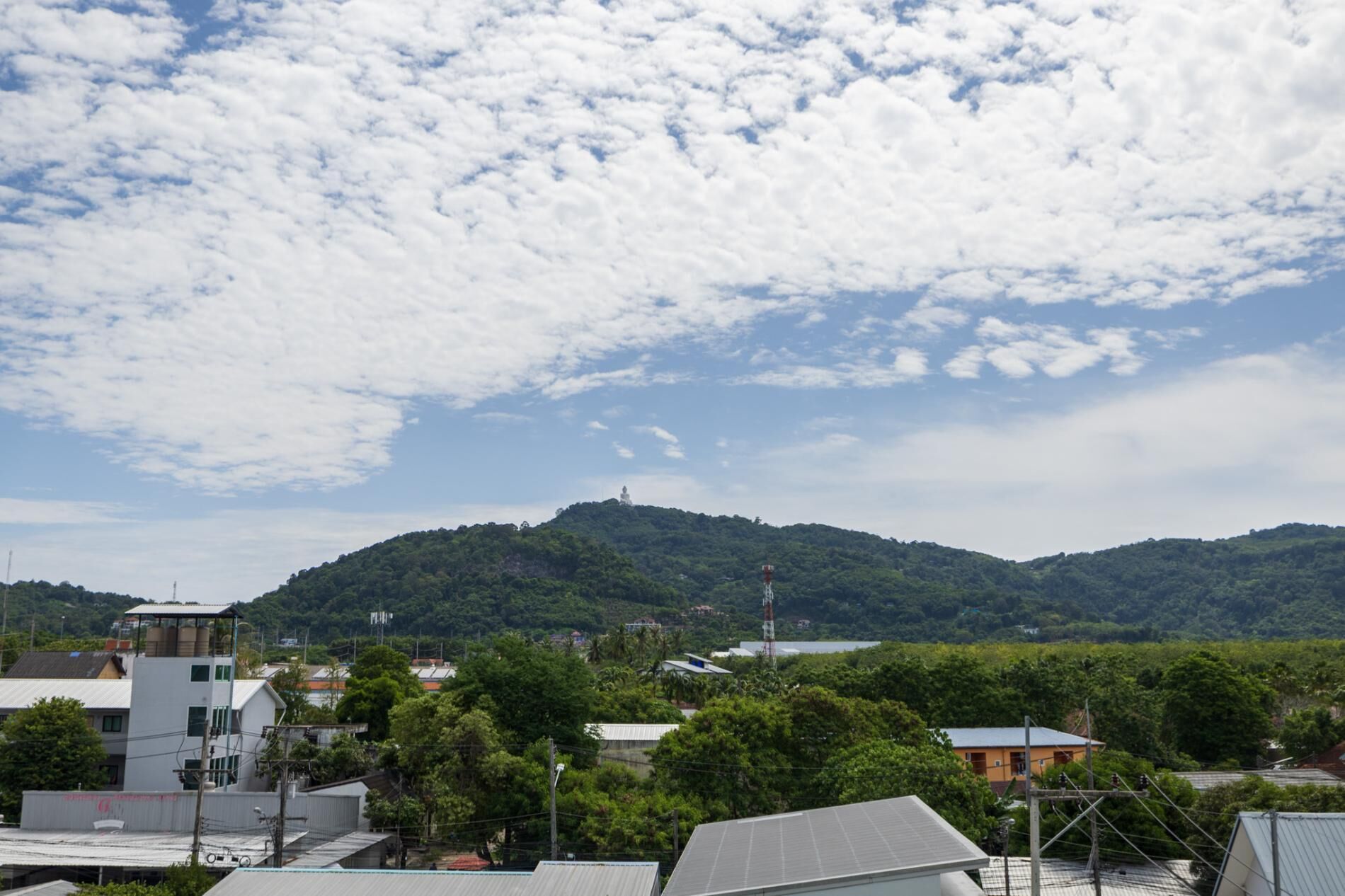 A view of a town with buildings and a hill in the background.