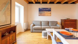 Una sala de estar con techo de madera, un sofá, una mesa de comedor, un mueble de madera y un mapa en la pared.