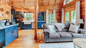 Een houten chalet van binnen met een keuken, eethoek en woonkamer.