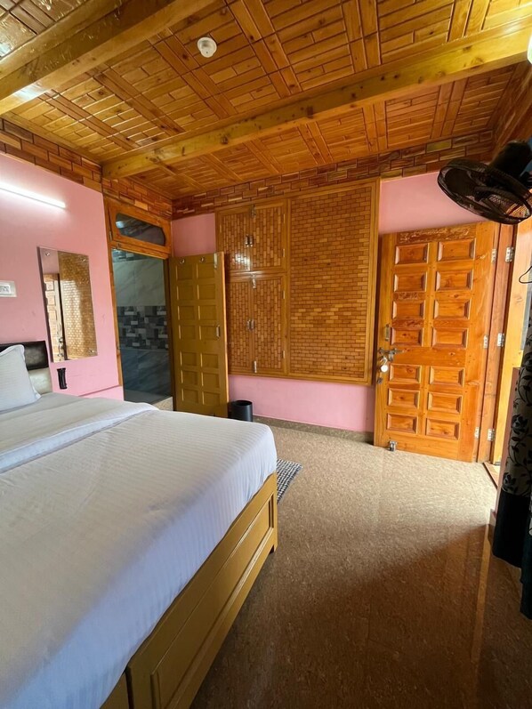 Un dormitorio con techo de madera, una cama, un armario y un espejo.