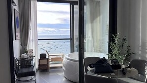 A room with a view of the sea, a seating area, and a small table with a plant. - EDGE Central holiday in pattaya (Pattaya)