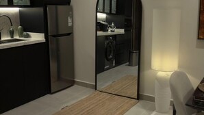 Een moderne keuken met donkere kastjes, een roestvrijstalen koelkast en een ingebouwde wasmachine.