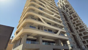 Een hoog gebouw met meerdere balkons en een modern architectonisch ontwerp.