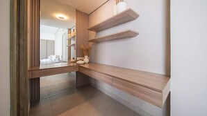 A modern bathroom with a wooden vanity, a mirror, and built-in shelves with toiletries. - Beachfront Villa W Private Pool & Sea Views (Ajmal Makan)