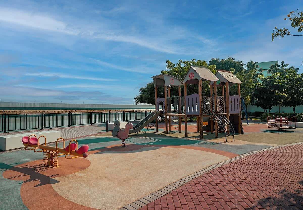 A playground with a seesaw, a slide, and a climbing structure.