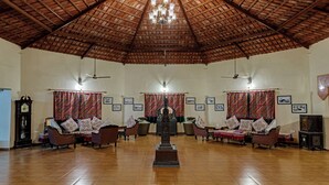 A spacious room with a high wooden ceiling, a central decorative structure, and multiple seating areas with patterned cushions. - Royal Safari Lakeside Resort- Little Rann of Kutch (Dasada)